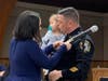 Police Chief Matthew J. Kline receives his chief's badge from his wife.
