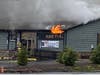 Flames can be seen coming from under the roof at Alba's Pub in Manchester on Friday morning