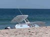 The boat Nothing But Net sits on the beach in Seaside Park Monday where it washed up after a breaching whale hit the boat. Two men on board were not injured. 