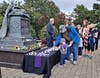 A man and his grandson place a candle at the base of the Angel in Anguish monument to honor those lost in the Sept. 11 terrorist attacks/