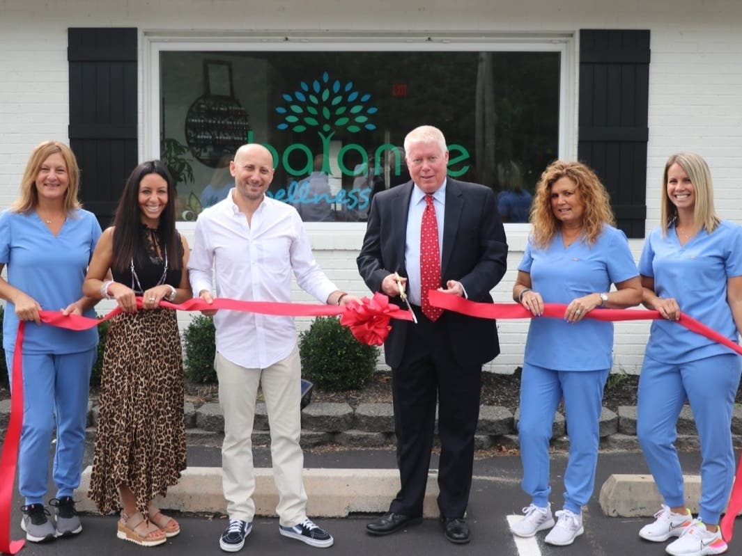 Mayor John Ducey cuts the ribbon at Balance Wellness Center's grand opening. The wellness center is owned by Jeff Hurewitz (to the left of Ducey) and Hurewitz's wife, Margo (to his left).
