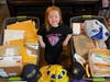 Sophia poses with some of the bins of mail Lavallette police received in reply to the request for patches. 