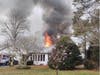 Flames shoot through the roof of a home on Willow Court on Friday. 