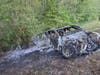 The remains of a burned-out BMW that went through guardrails on the southbound shoulder of the Garden State Parkway on Monday. 