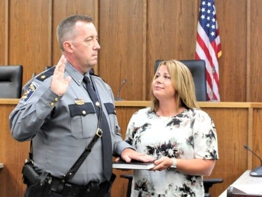 Chief Robert M. Dolan takes his oath of office as Chief of Police as his wife holds the Bible. 