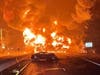 Flames billow into the air after a tanker carrying 8,700 gallons of gasoline overturned on Route 37 early Wednesday as the driver tried to avoid the car in the foreground. That car had hit a deer. The driver was out of the car and not injured. 