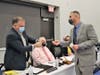 Retiring Superintendent David Trethaway presents incoming Superintendent John Berenato with a Manchester Hawk pin to welcome him to the district. 