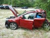 The 2011 Kia Forte driven by Grace Newchurch, who was rear-ended by a 2000 Peterbilt dump truck on Monday. In the background, a white GMC work van that was involved in the crash is visible. 