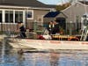 Firefighters with East Dover Fire Company work to rescue a deer that was found swimming in a Snug Harbor lagoon Monday.