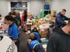Volunteers wrap gifts and assemble bicycles.