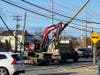 A small excavator is tangled in power lines on Hooper Avenue in Toms River on Friday. 