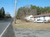 A broken utility pole lies across Ridgeway Road on the left side of this photo. The Lincoln Town Car hit the pole before hitting the house, police said. 