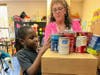 A student checks cans of donated food for the Regional Day School "Soup"er Bowl donation Drive. 