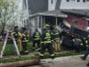 Firefighters inspect the damage to a home at the corner of McLean Avenue and Route 35 north in Point Pleasant Beach where a dump truck crashed into it.