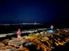 First responders walk along the jetty at Manasquan Inlet while searchers looked for a missing person following a boat crash Thursday night. 