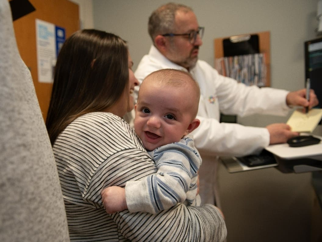 Ryan Moser was all smiles at a recent checkup as Dr. Mark Kaytan (rear) goes over his report with Ryan's other Katie and father Matt (foreground)
