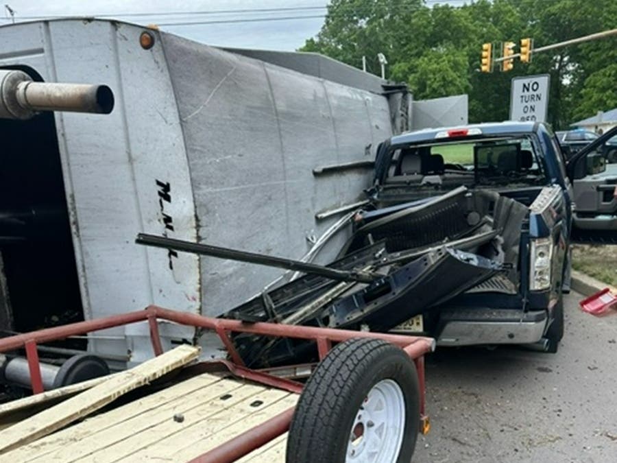 A garbage truck rolled onto a pickup truck that was waiting to turn onto Route 70 on Thursday.