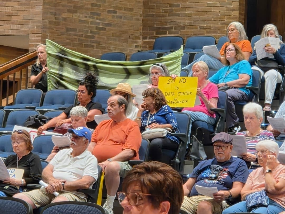 Manchester residents hold signs opposing data centers in the township. The council on Monday voted to approve an ordinance removing a provision for data centers from a redevelopment plan. Residents wanted more.