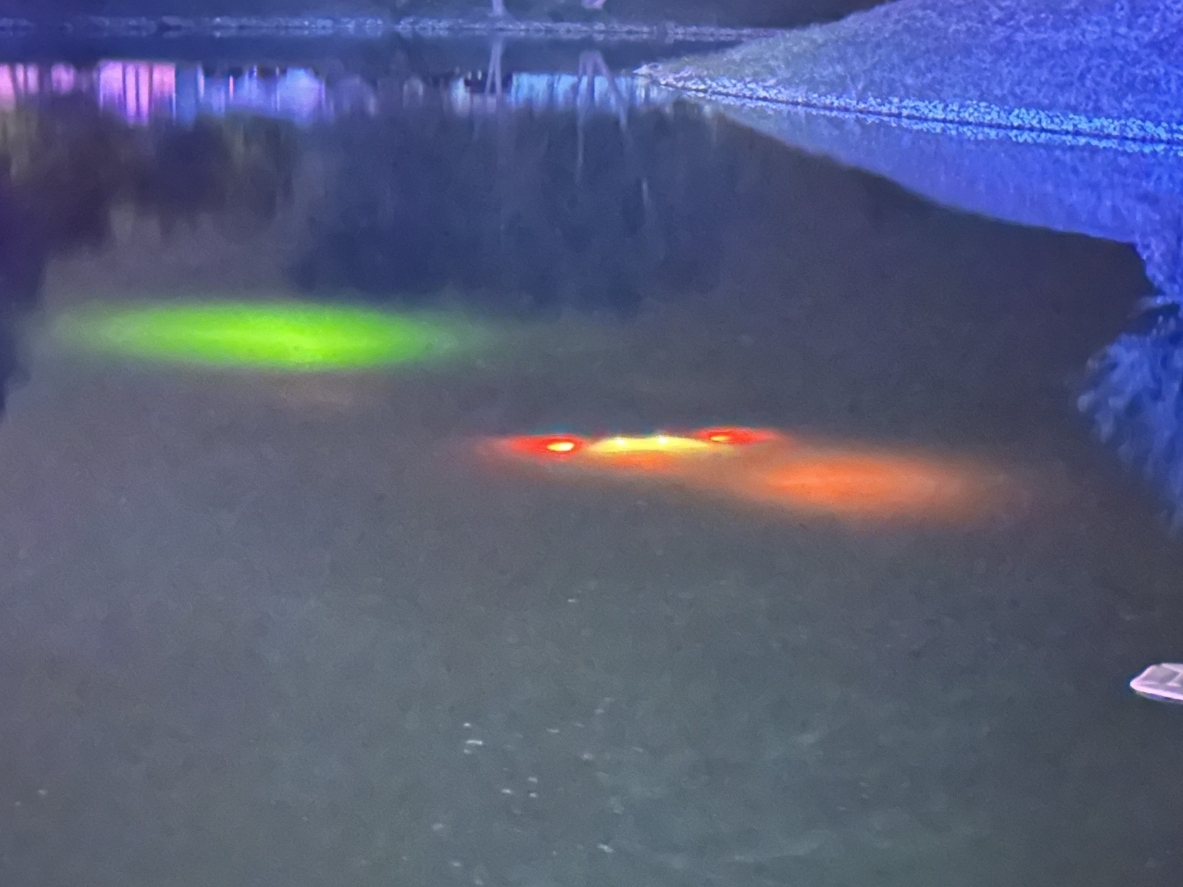 The lights of George Migner's Nissan Altima can be seen as the car sits completely submerged in a water hazard in Manchester.