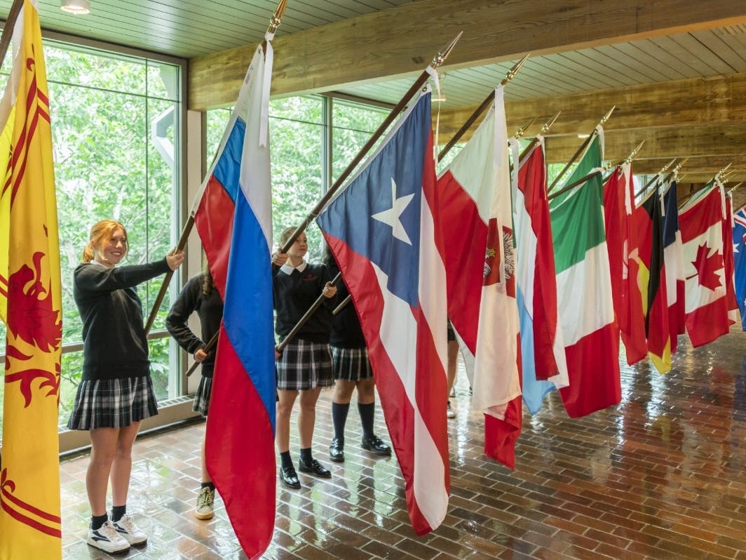 Flag bearers prepare to process into Woodlands Academy’s chapel as part of the school’s Flag Ceremony on Sept. 4. The 26 flags this year represent nations where a Woodlands student or adult community member was born or holds dual citizenship. 
