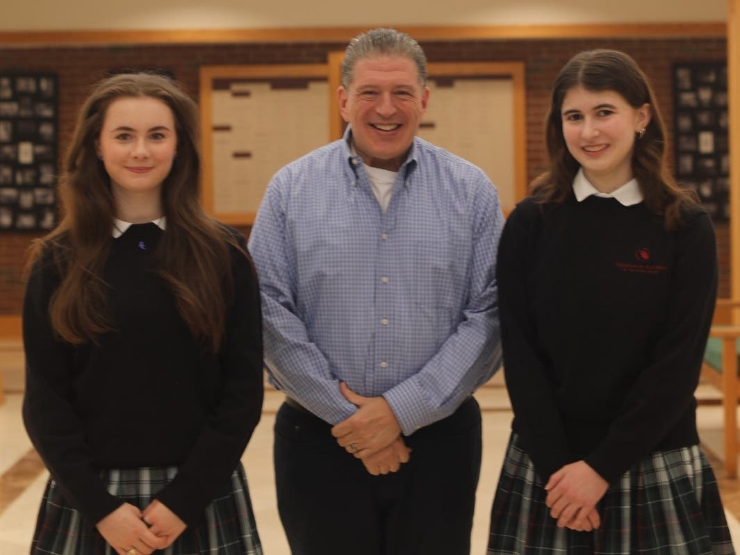 Woodlands Academy seniors Elisa McCusker (left) and Claire Caserio, pictured here with Associate Head of School for Academics Rocco Gargiulo, are among the 2027 National Merit Scholarship Semifinalists advancing to the next step in the competition.