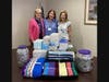 Left to right: Claire Burling, Aideen O’Donnell, and Kim Rowe with members’ donations of items for hospitals and care facilities.


