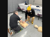 Rutgers New Jersey Medical School student Ronald Bangiyev (left) performs a demonstration during a walk-by Hands-Only CPR training at a University Hospital fair.
