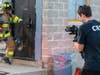 A videographer captures a Ship Bottom firefighter using training and tools to pry open a door.
