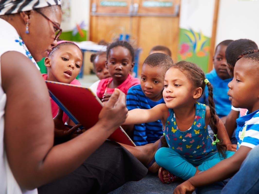 Teacher reading a book with a class of preschool children