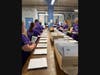 Volunteers from Point32 Health assembling braille children's books