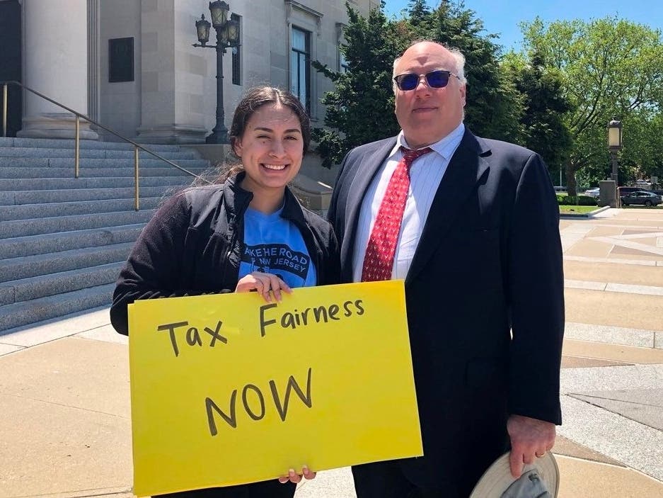 An activist with Make the Road New Jersey advocates for “tax fairness” with Morris Pearl, at right.