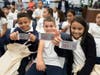 Students at Elliot Street Elementary School in Newark hold up their new library cards.