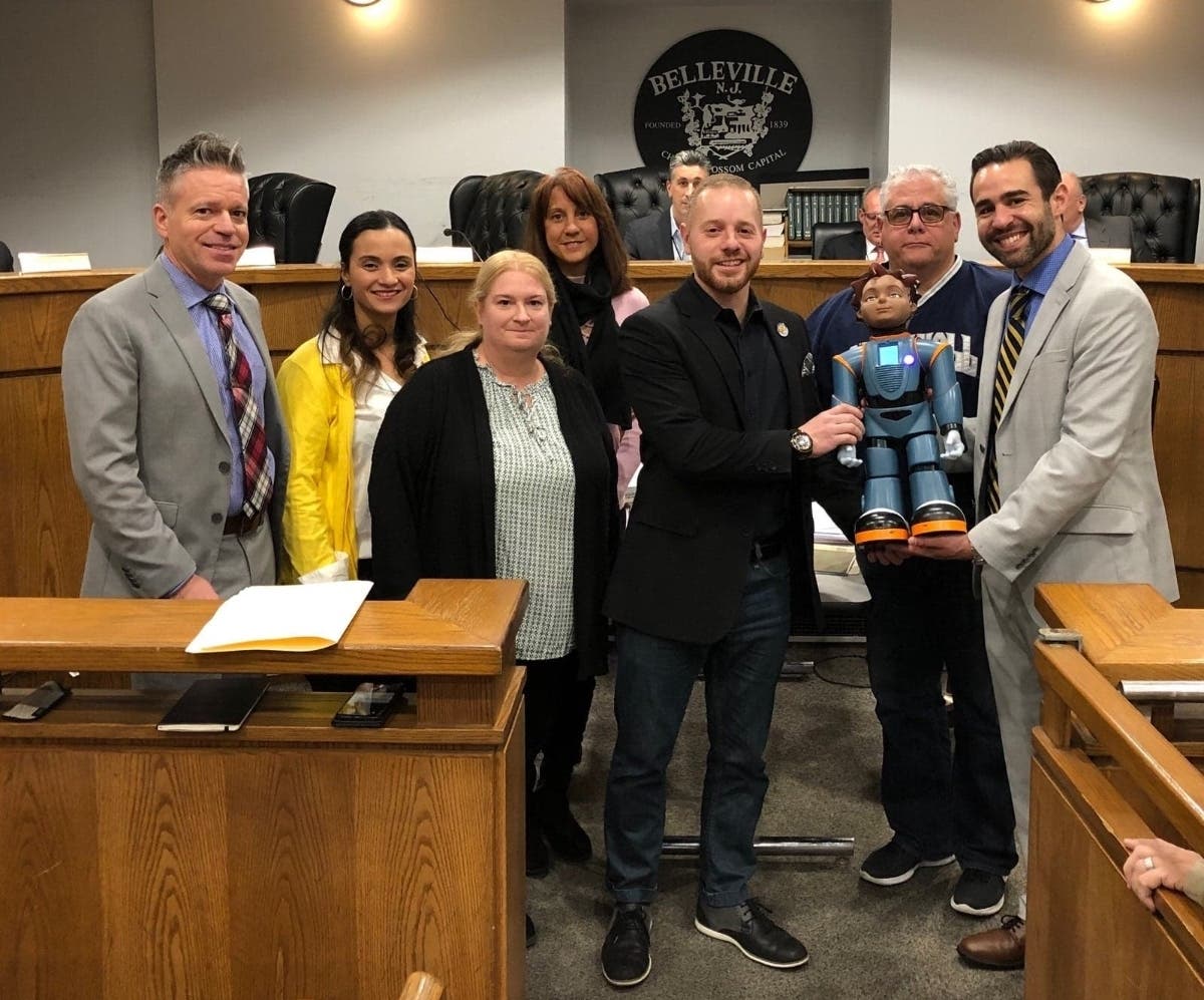 Deputy Mayor Vincent Cozzarelli, center, helps hold Milo, a new robot that Belleville will use in working with students with autism.