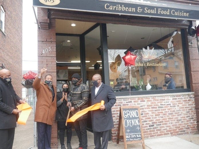 Local and Black-owned Tasha's Caribbean and Soul Food opens to a round of applause from community members in East Orange, NJ.