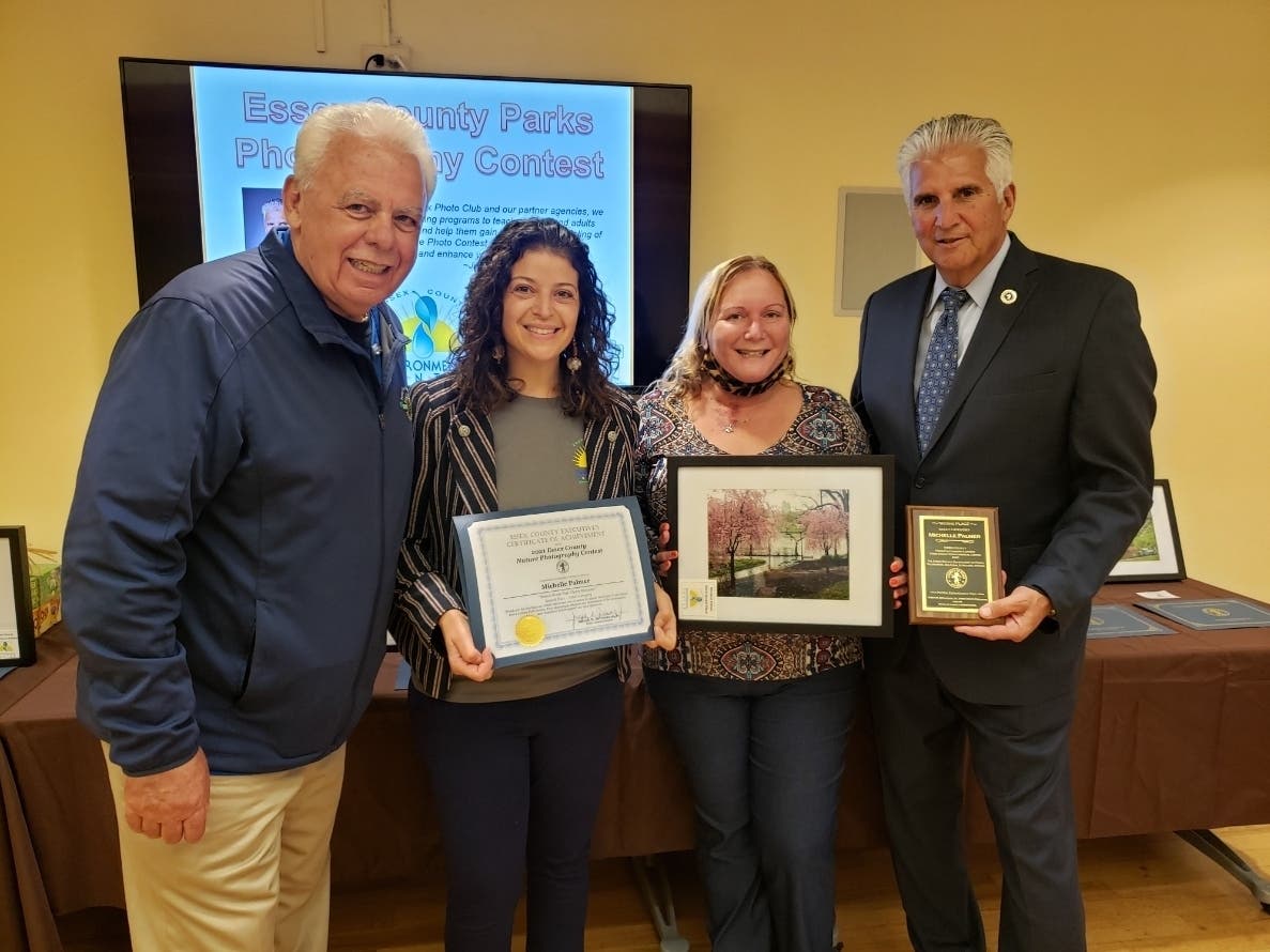 Essex County Executive Joseph DiVincenzo, Jr. (right) congratulates Michelle Palmer (second from right) from Belleville for winning an award in the Essex County Parks Photography Contest.