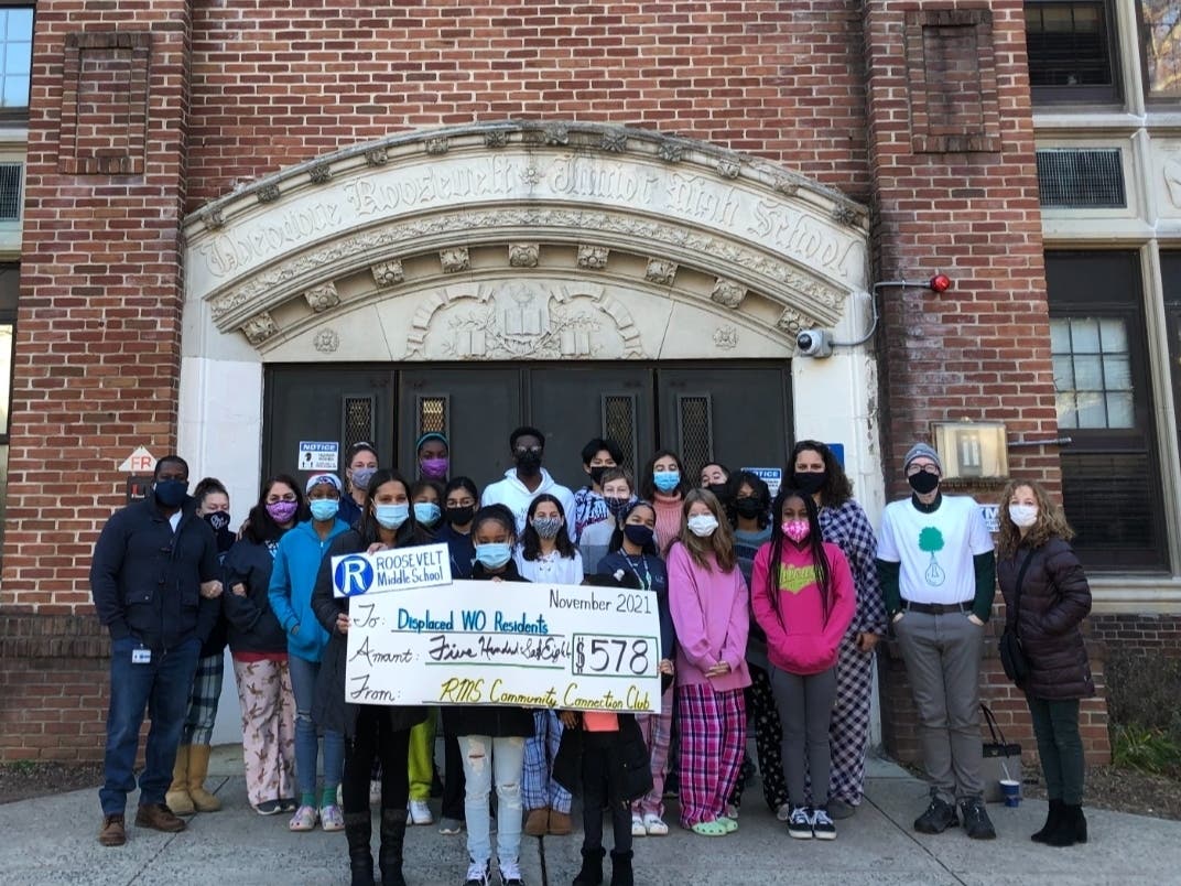 Our Green West Orange and displaced West Orange residents receive a fundraising check from students and staff of Roosevelt Middle School’s Community Connection Club.