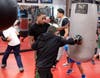 Anthony Johns observes a young boxer's punching form.