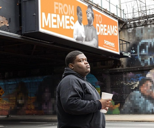 Dieunerst Collin, who saw massive internet fame after a viral video in 2013, poses in front of a billboard in Essex County, New Jersey. The teen recently signed a name, image and likeness deal with Popeyes.