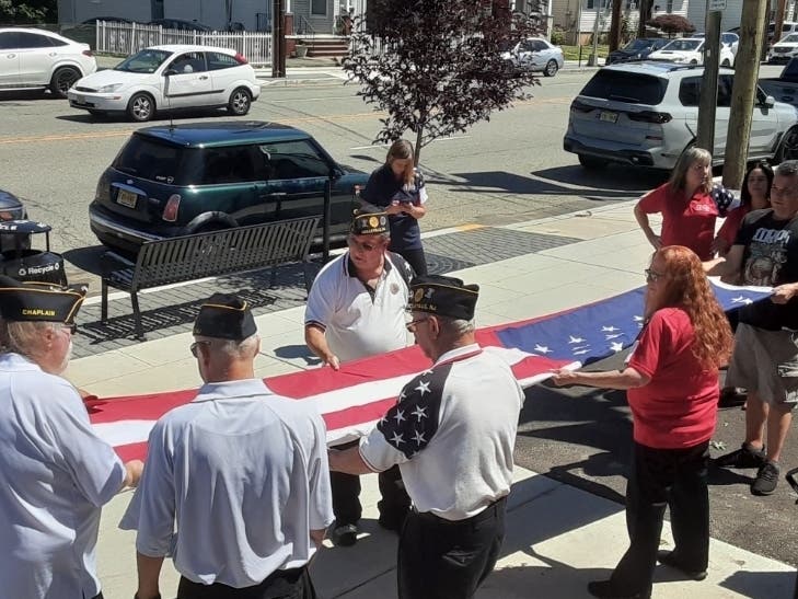 Veterans and auxiliaries at Belleville American Legion Post 105 hold a super-sized U.S. flag in preparation for the July 4 festivities.