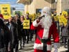 A costumed Santa leads flight attendants on a chant during a rally outside of United Airlines' terminal at Newark Airport in New Jersey on Dec. 19, 2024.