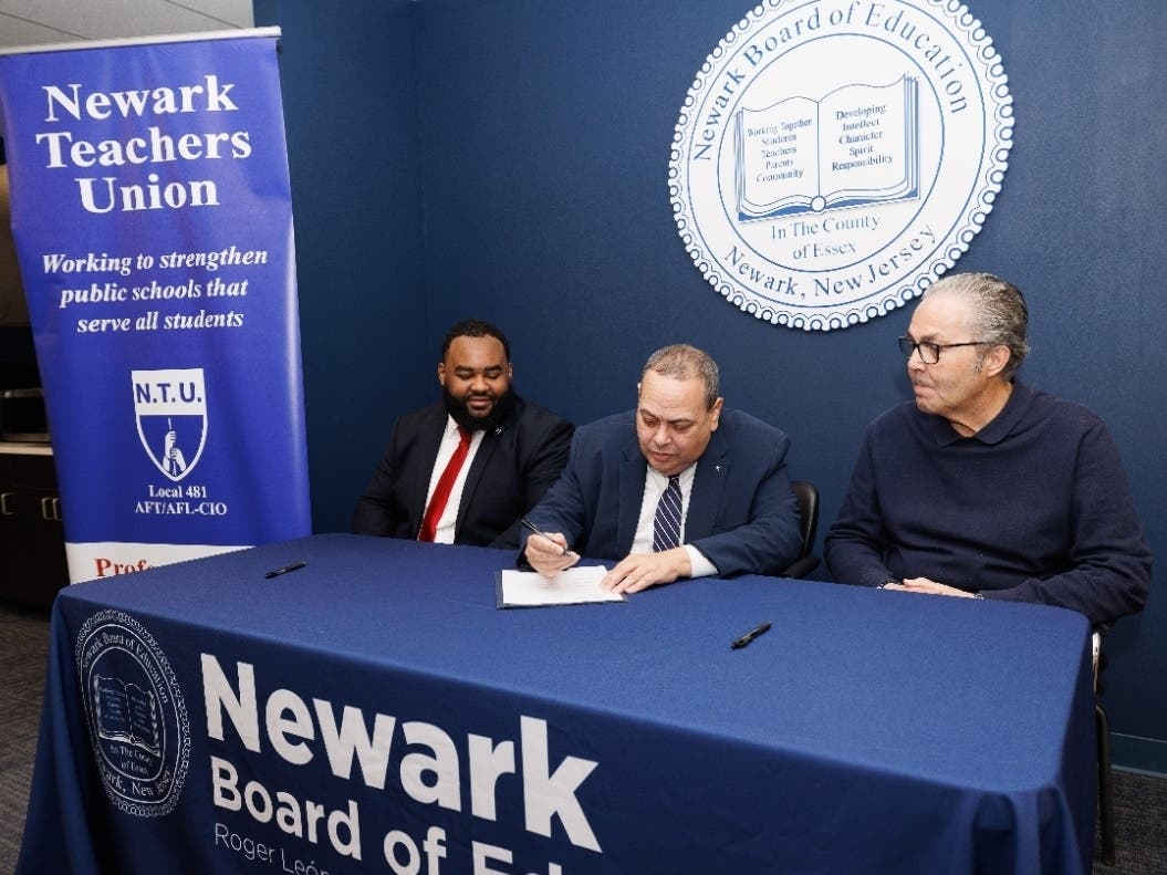 Superintendent León signs the ratified five-year contract flanked by BOE President Council and NTU President Abeigon.