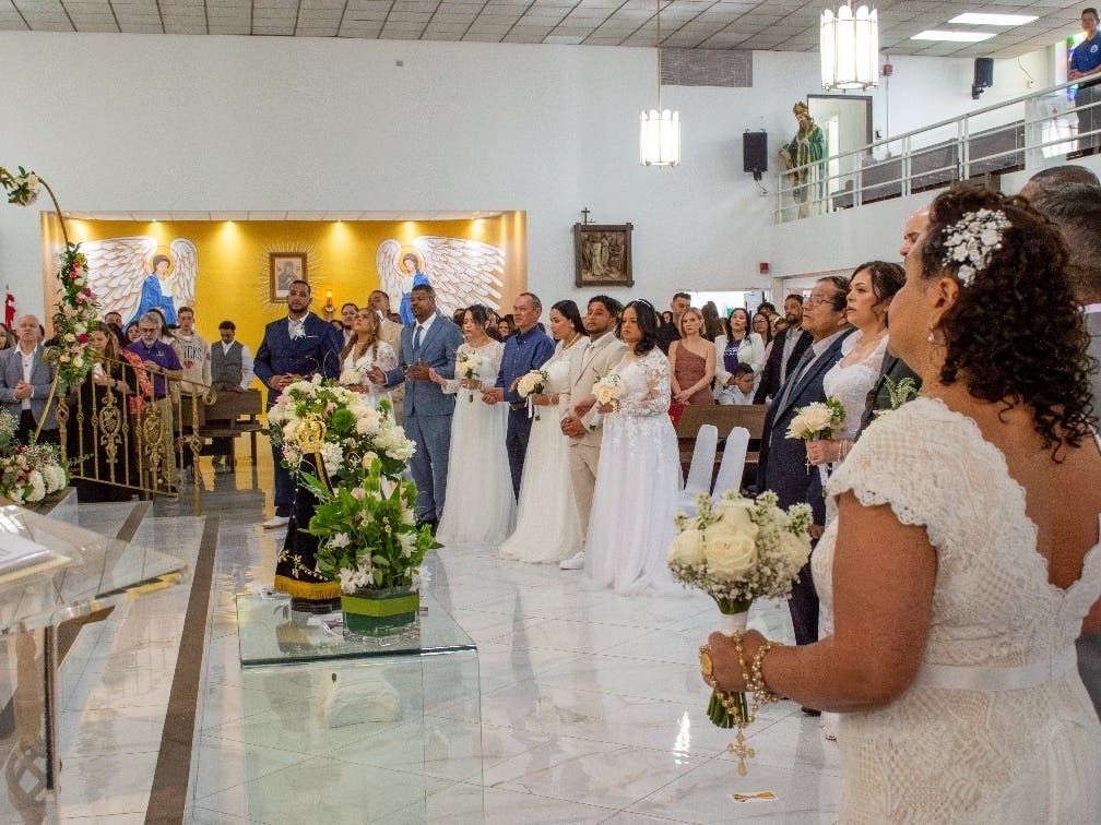 A church community in New Jersey came together to help eight couples exchange vows during a group wedding ceremony at St. James Church in Newark on Valentine’s Day.