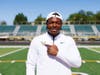 Adekunbi Adetayo proudly shows off the logo of the college where he will play football.