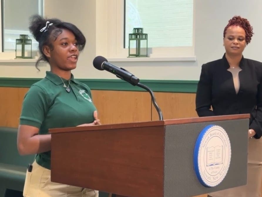 Nakira Poole speaks at a press conference for the official opening of the 403 Salon & Spa. In the background is teacher, Nicole Daniels.