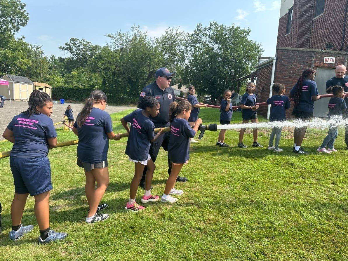 Participants run through hose drills at an annual youth firefighting camp in Essex County, New Jersey.