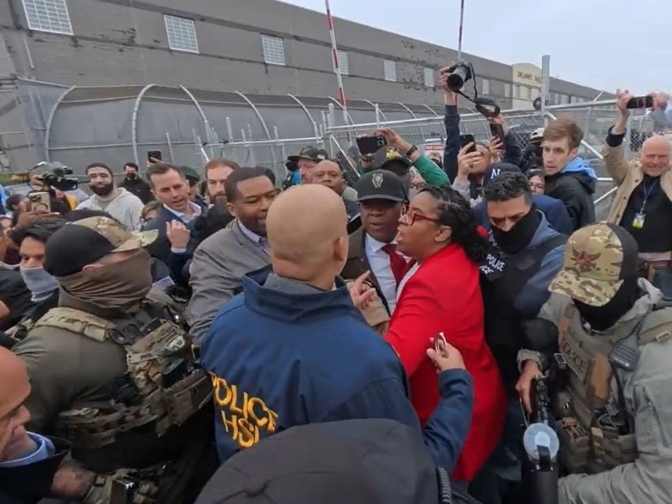 U.S. Rep. LaMonica McIver of New Jersey (seen in red jacket above) stands outside Delaney Hall in Newark on May 9, 2025. The prison holds ICE detainees from across the state.