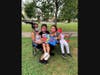 A family shows off the books they received at a read-aloud for rising pre-kindergarteners.