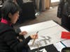 Artist, Wei-Ting Chuang, demonstrating the ancient art of calligraphy during the reception