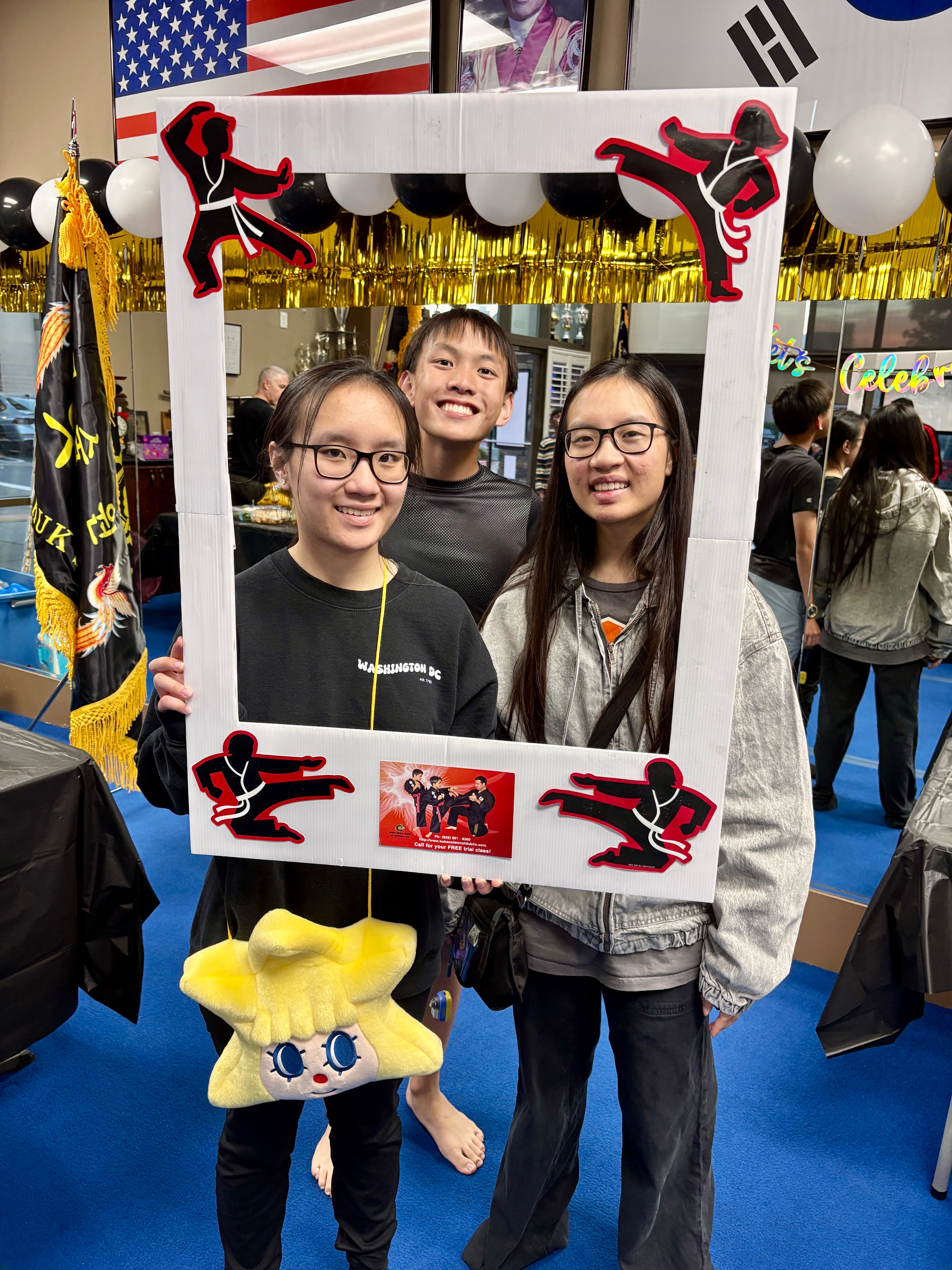 Three Martial Arts Gran Champions posing in a photo frame