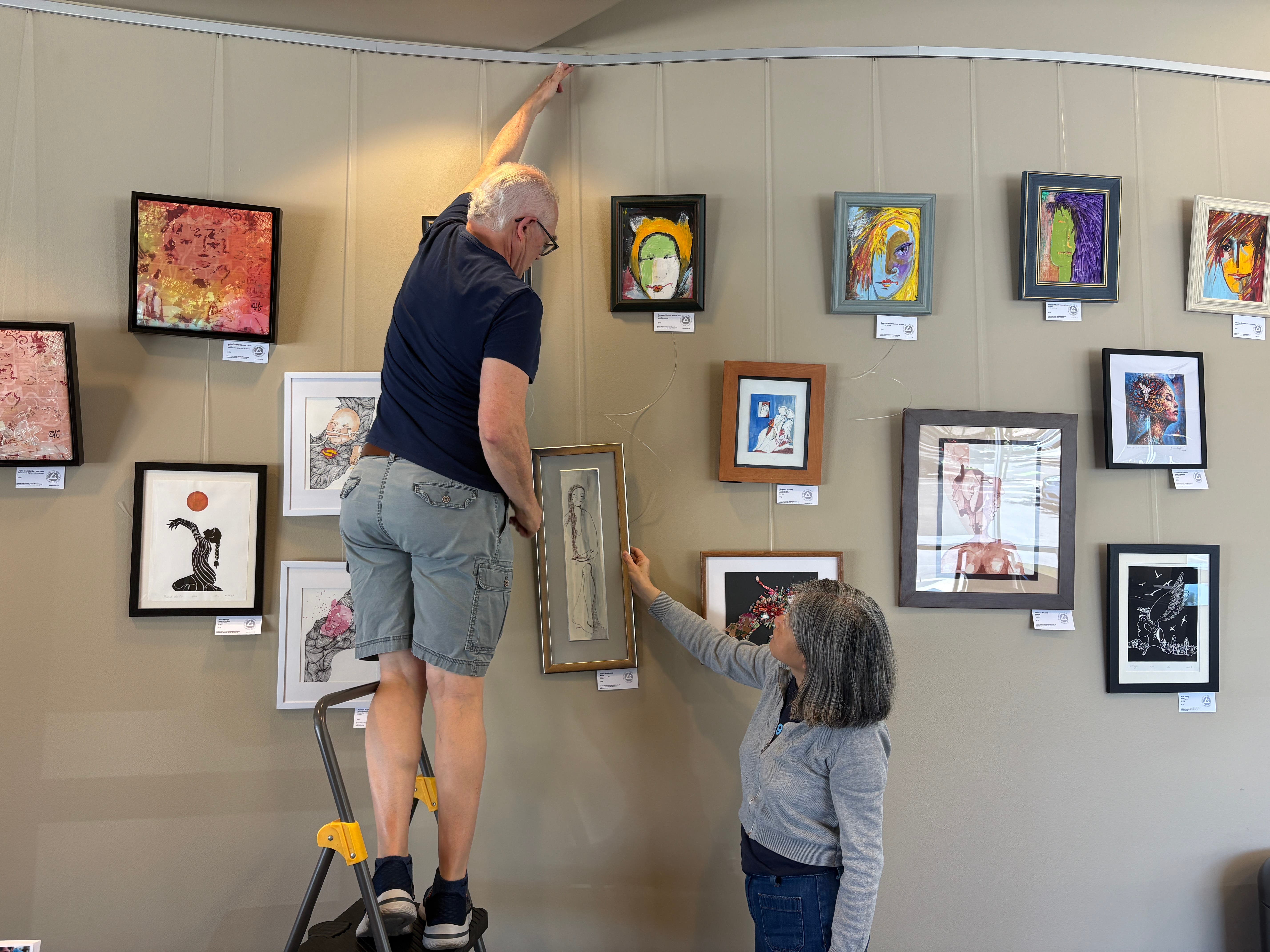 Artists hanging artwork